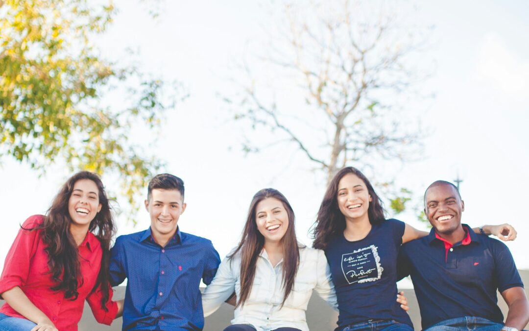 Group of diverse teenagers smiling together after high school graduation, ready for college, trade school, military, or work.