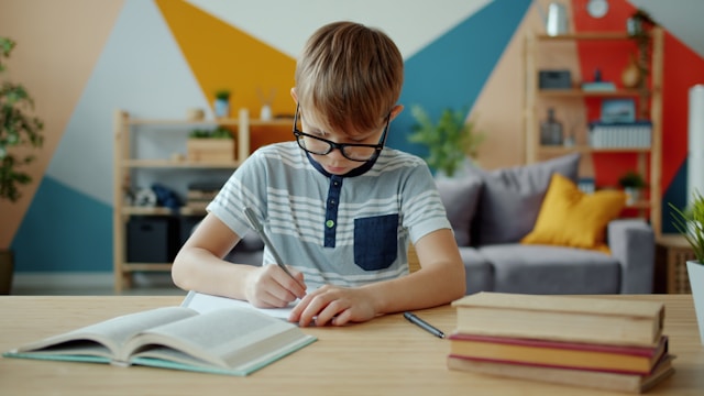 Boy wearing glasses doing homework at home, illustrating learning challenges and the need for a psychoeducational evaluation.
