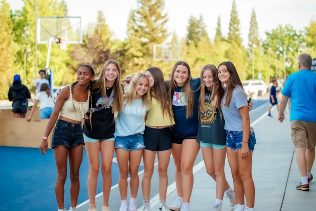 Group of teenage girls standing side-by-side with their arms around each other, symbolizing friendship, support, and positive teen mental health.