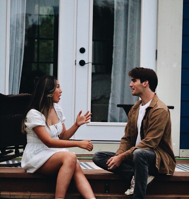 Two adults sitting together and having a supportive conversation, illustrating how to help someone you love who is experiencing anxiety.