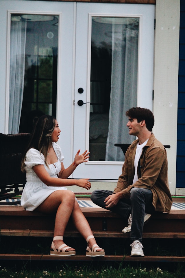 Two adults sitting together and having a supportive conversation, illustrating how to help someone you love who is experiencing anxiety.