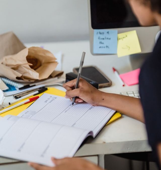 Teenager using a planner and checklist to organize tasks, illustrating executive functioning skills such as planning and time management.