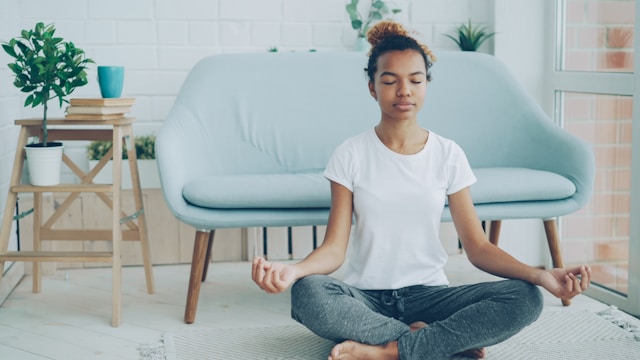 Person practicing slow breathing in a peaceful room, illustrating healthy techniques for calming the nervous system during anxiety.